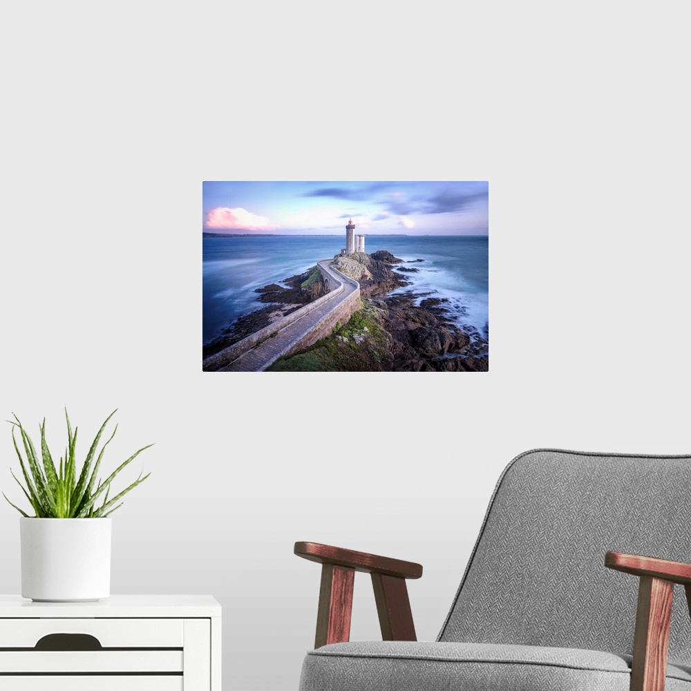 A modern room featuring Fine art photo of a lighthouse at the end of a rocky peninsula in France.