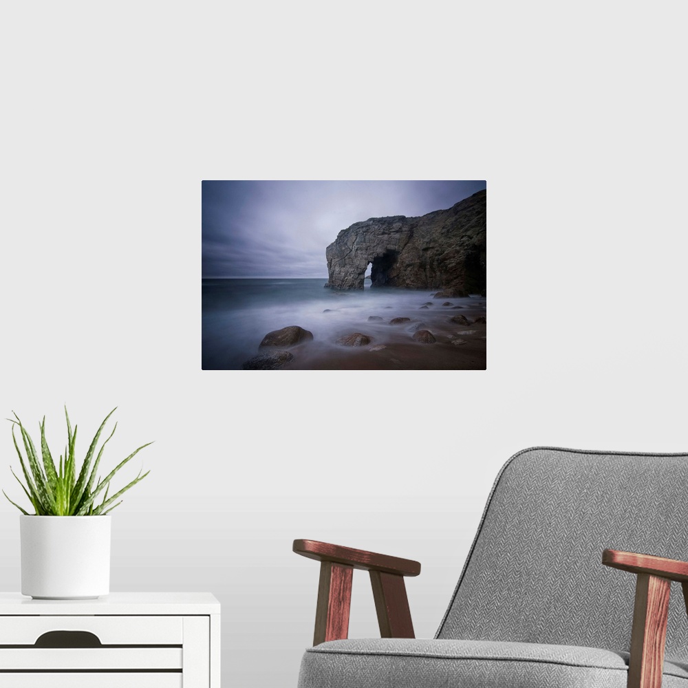 A modern room featuring He natural arch rock in Quiberon island in Britany at high tide, a long colored time exposure, sa...