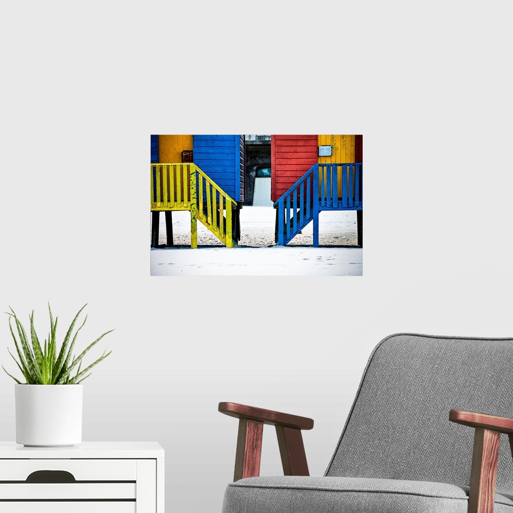 A modern room featuring A photo of colorful buildings that have been painted in primary colors over a white snowy landscape.