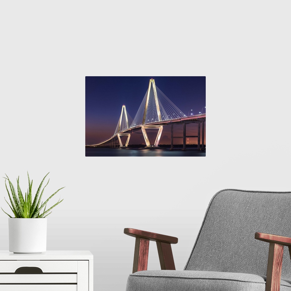 A modern room featuring White towers and cables of the Cooper River Bridge in Charleston, South Carolina, at sunset.