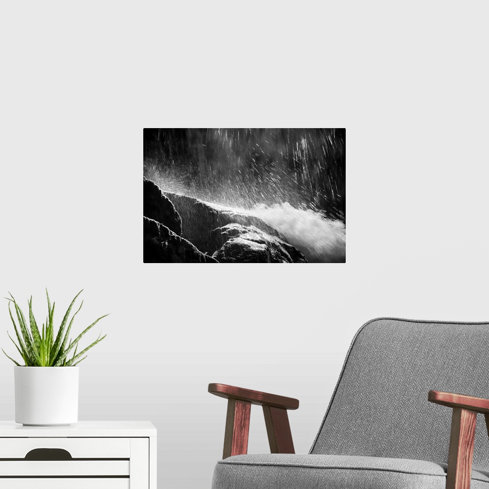 A modern room featuring Black and white photograph of water falling from the top and rushing down rocks.