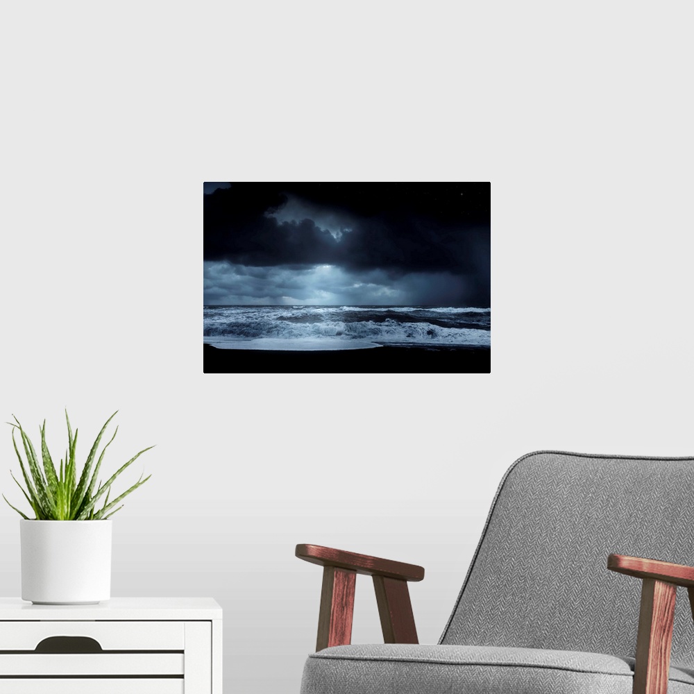 A modern room featuring A photograph of a dark rugged coastline under a dark sky.