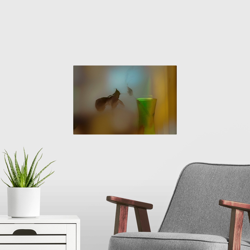 A modern room featuring A soft of focus photo of a dying plant inside a vase.