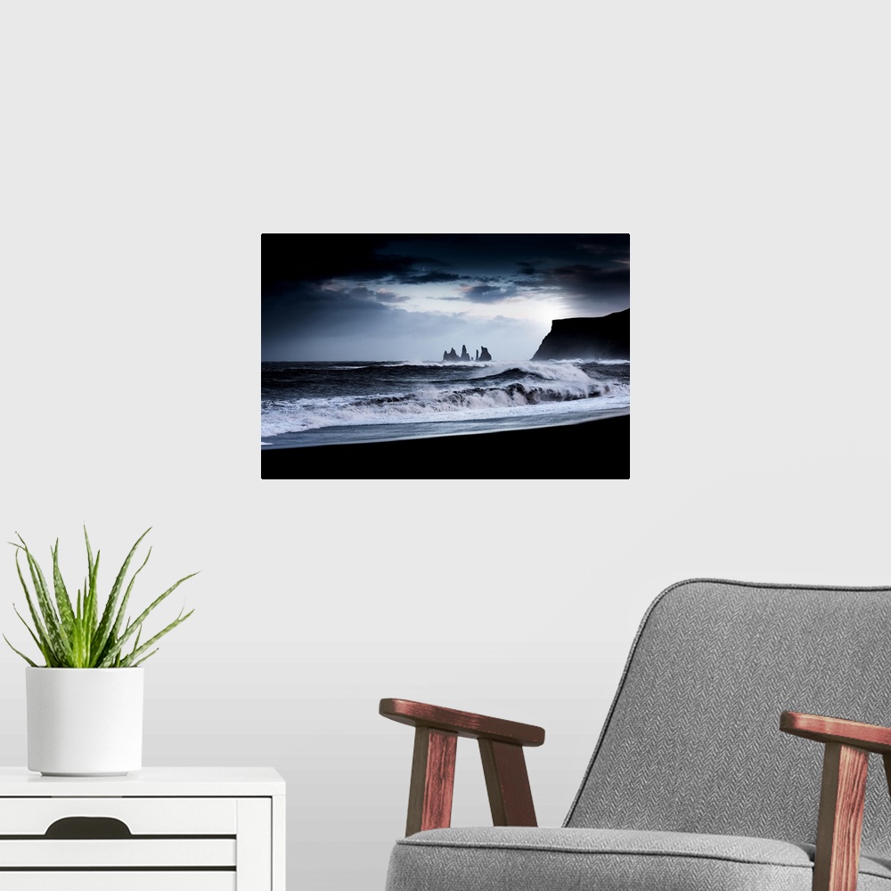 A modern room featuring A photograph of a dark rugged coastline under a dark sky.