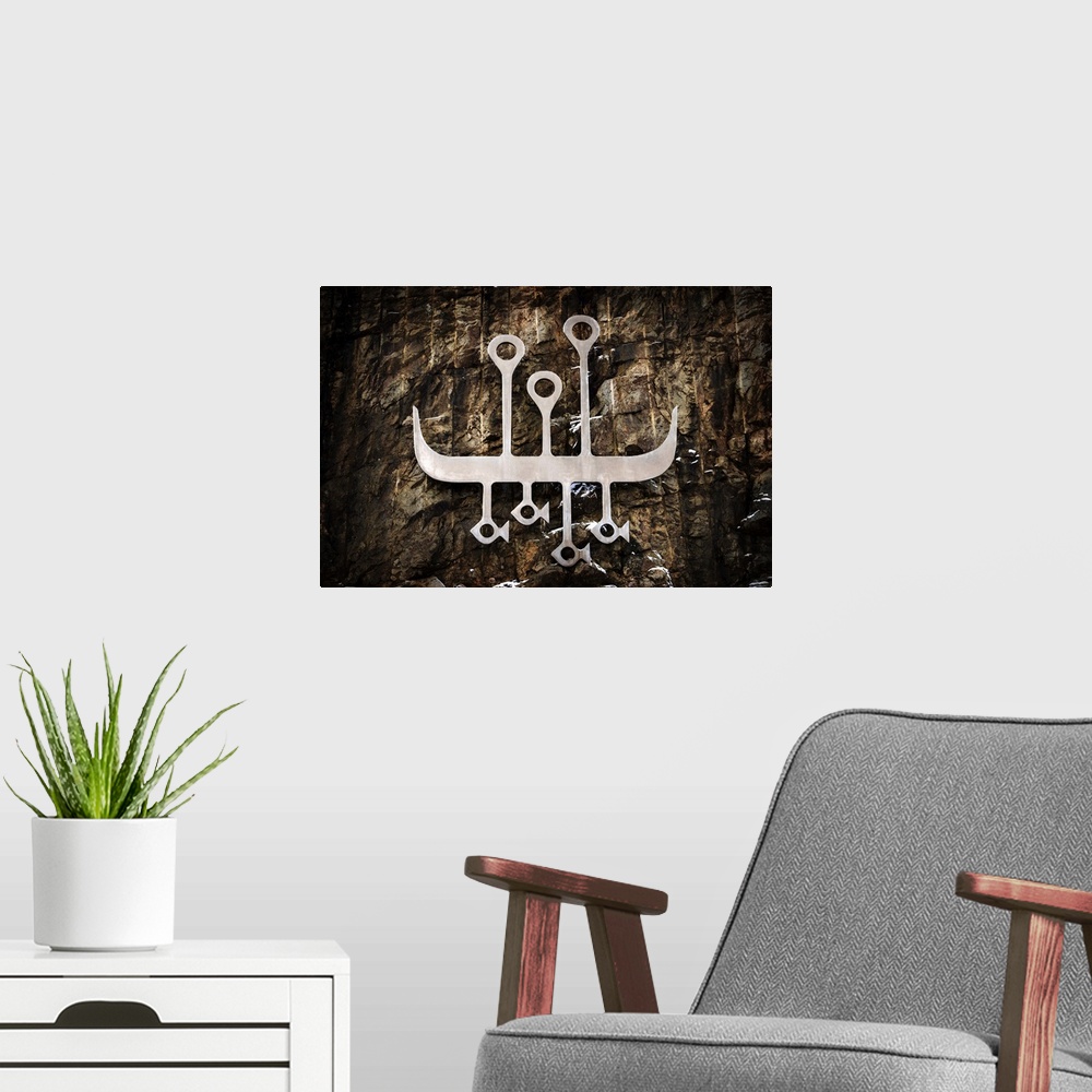 A modern room featuring A photograph of a tributary metal carved symbol of the vikings.