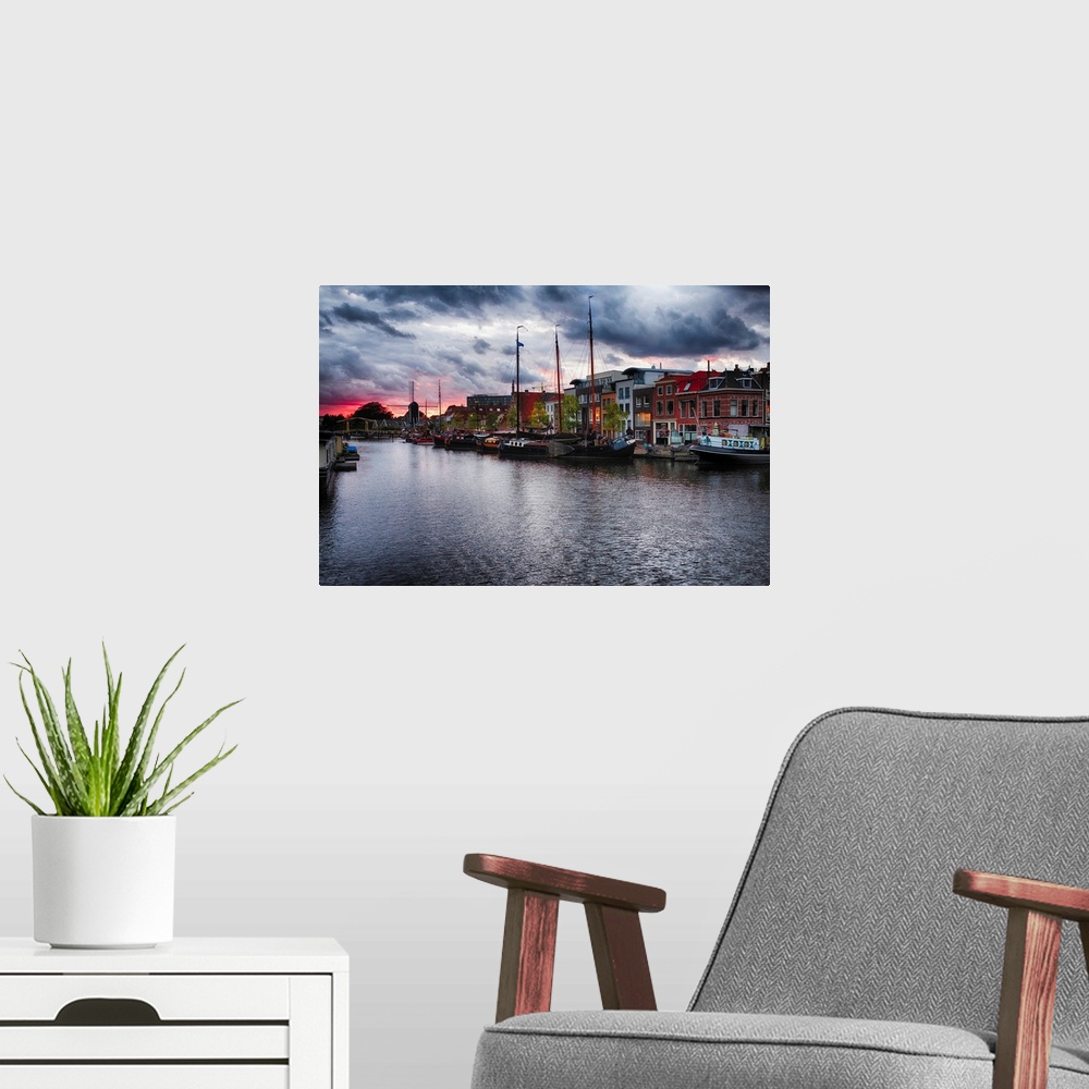 A modern room featuring Canal with old ship, windmill, and a drawbridge at sunset, Leiden, Netherlands.