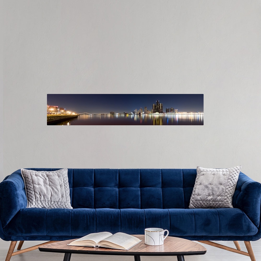 A modern room featuring Panoramic image of the Detroit skyline in the evening with the buildings and lights mirrored in t...