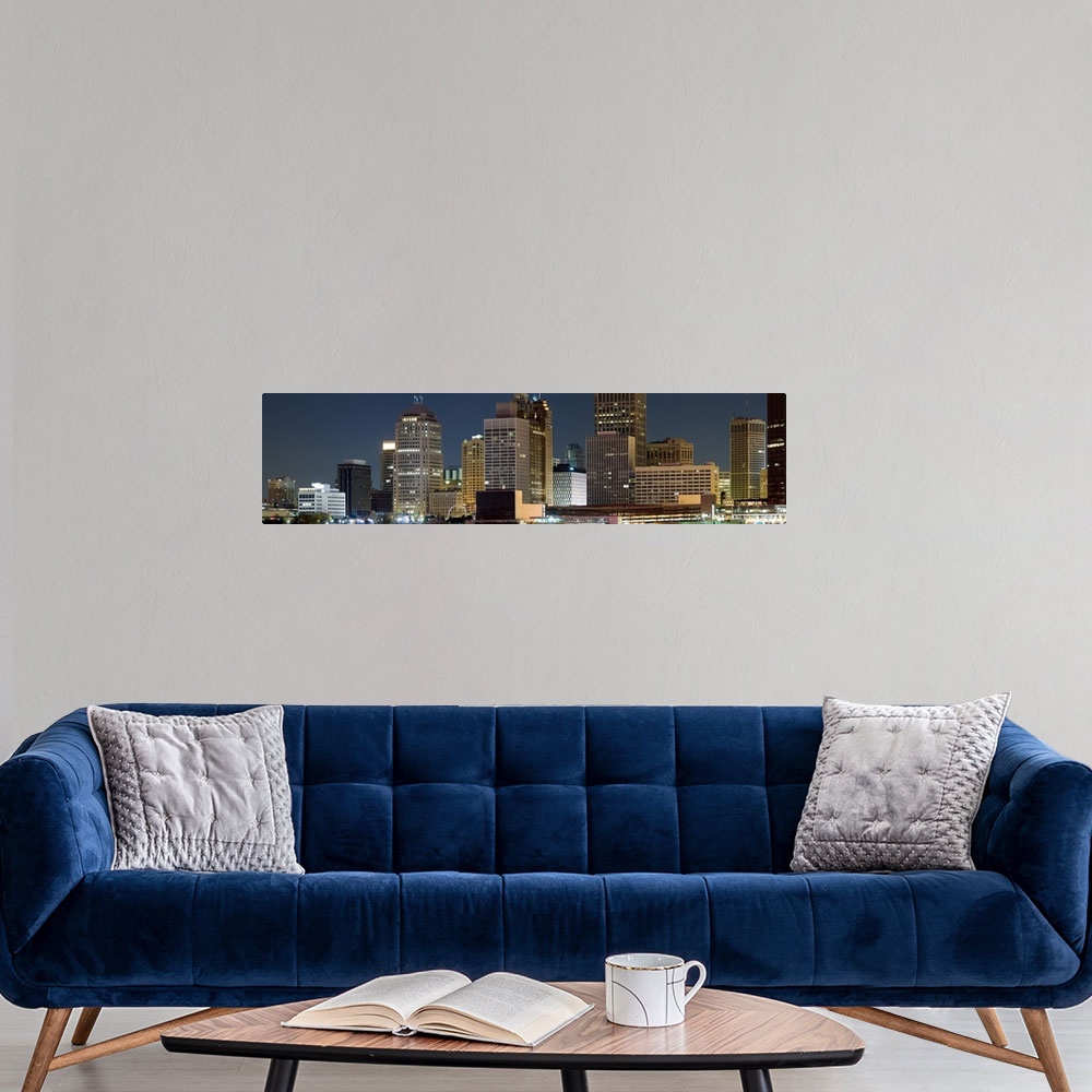 A modern room featuring Oversize horizontal photograph of lit skyscrapers against a deep blue sky at night, in Detroit, M...
