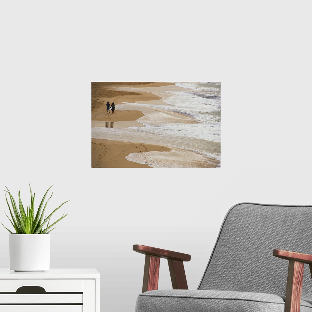 A modern room featuring Giant photograph displays two people holding hands and strolling down a sandy shoreline while the...