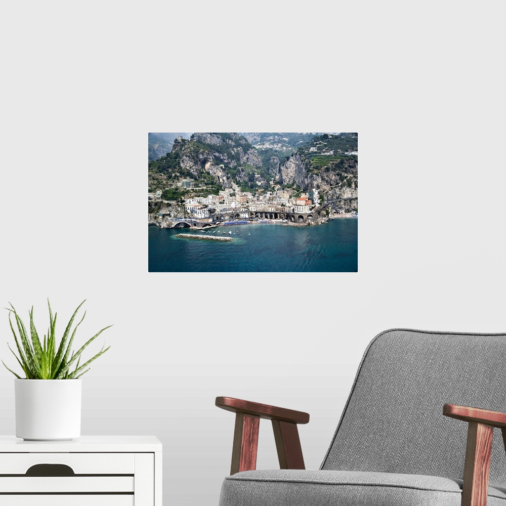 A modern room featuring This decorative wall art is an aerial photograph of an Italian village and harbor build into stee...