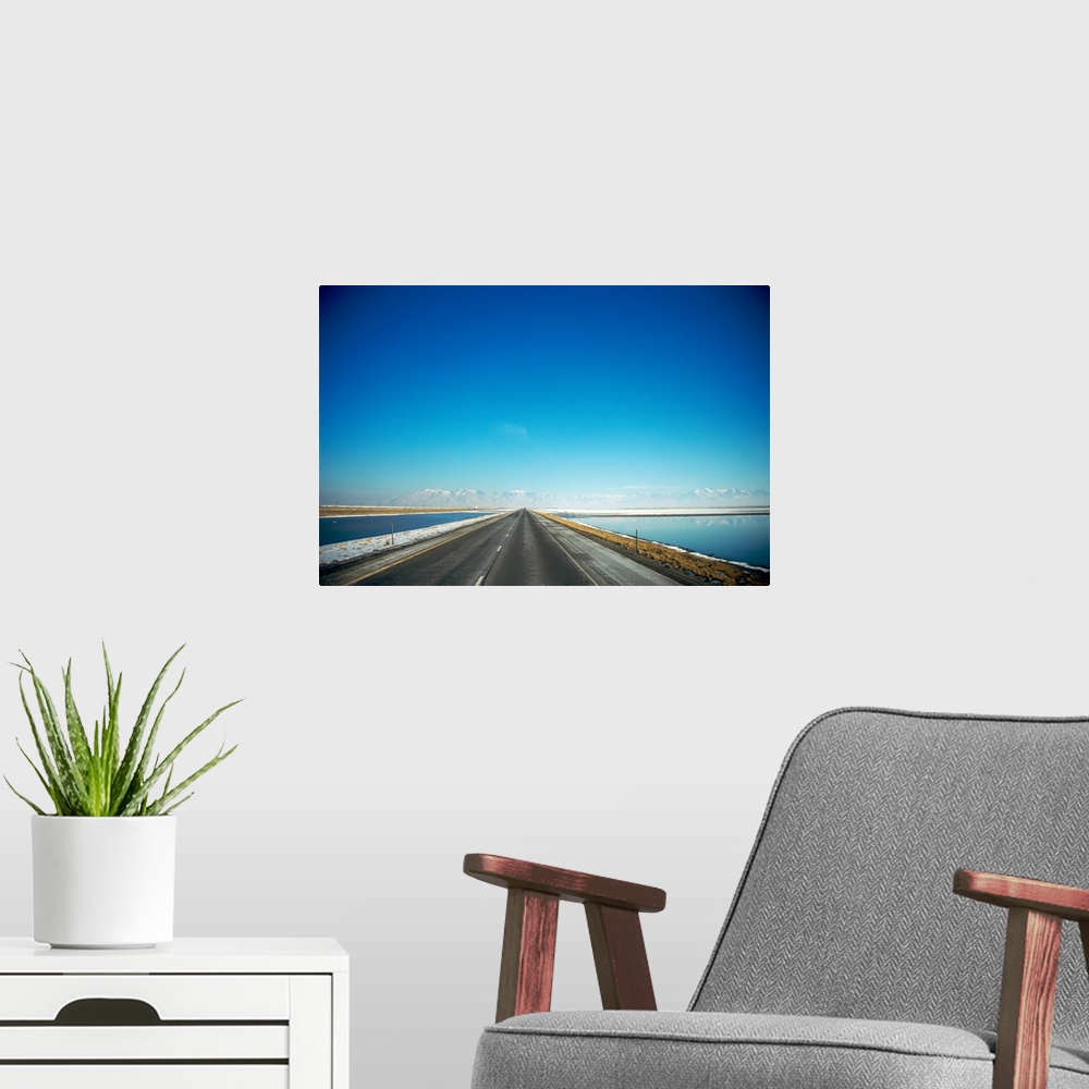 A modern room featuring Highway along a lake with snow covered mountains in the background, Interstate 80, Tooele County,...