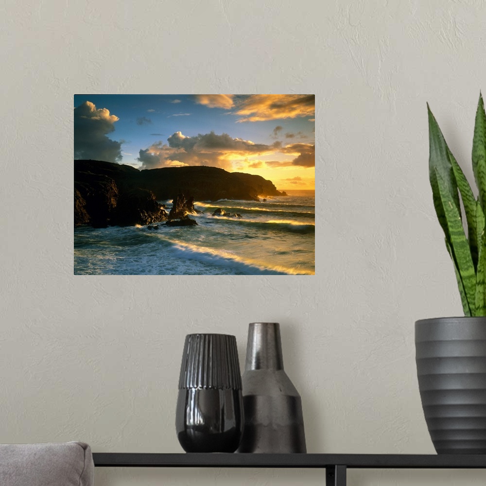 A modern room featuring Photograph of rock cliffs in ocean with waves rolling in under a cloudy sky at sunrise.