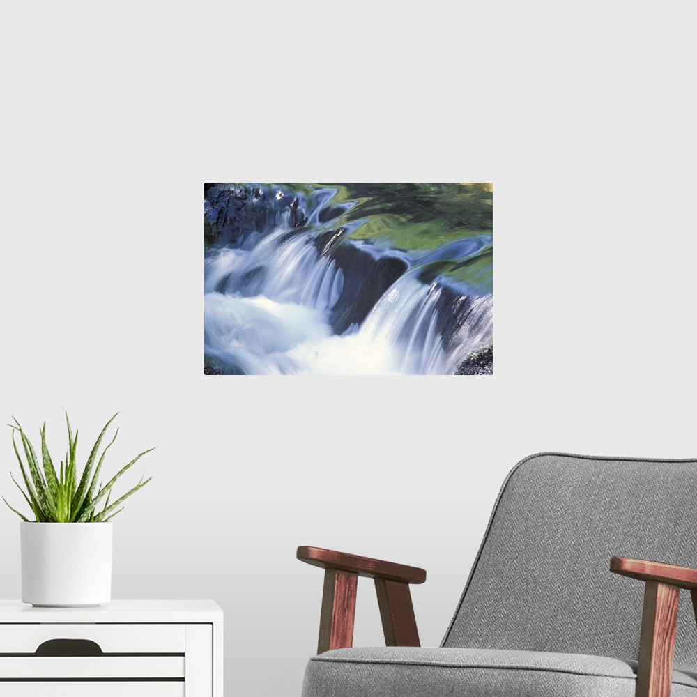 A modern room featuring Up-close photograph of water flowing over huge rocks.