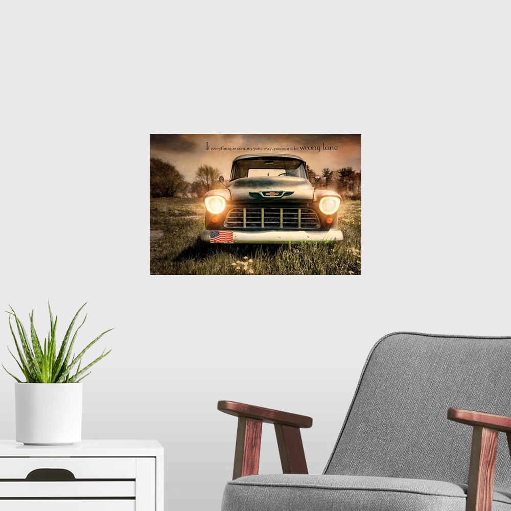 A modern room featuring A vintage truck with its headlights on in a field.