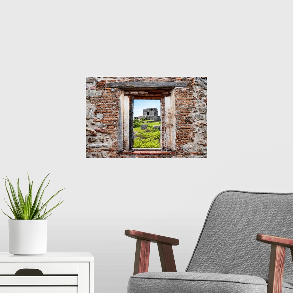 A modern room featuring View of the ancient Mayan fortress in Tulum, Mexico, framed through a stony, brick window. From t...
