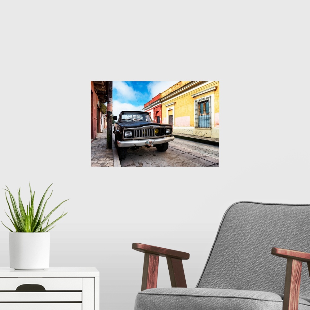 A modern room featuring Photograph of an old black Jeep parked on the side of a colorful street in Mexico. From the Viva ...