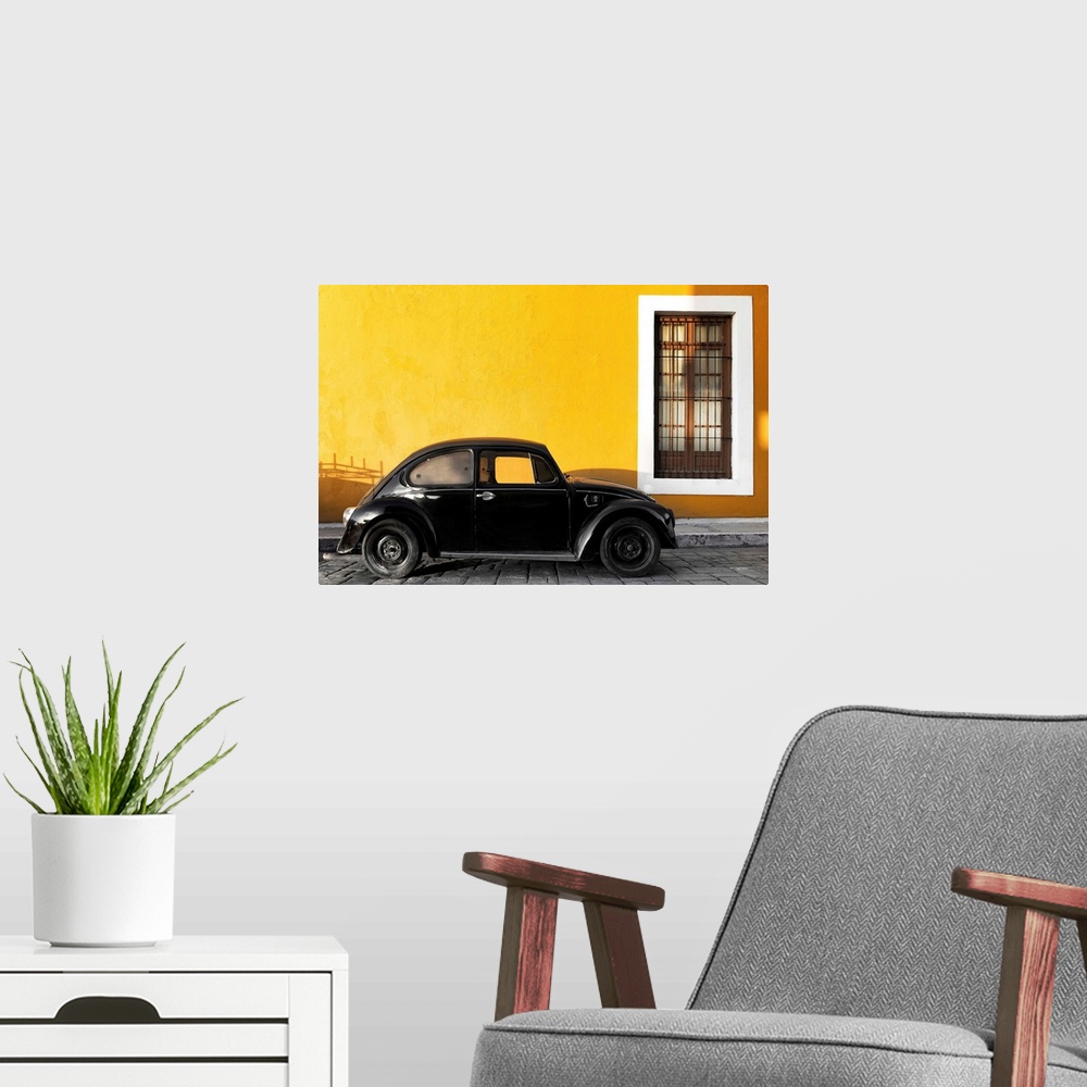 A modern room featuring Photograph of a black Volkswagen Beetle parked on the street in front of a gold exterior wall. Fr...