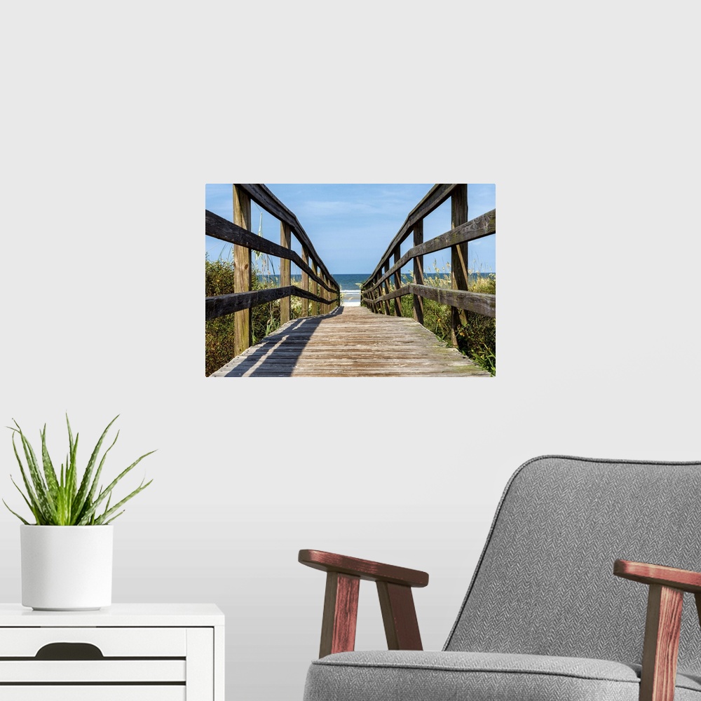 A modern room featuring Wooden boardwalk leading to the sandy beach on the coast.