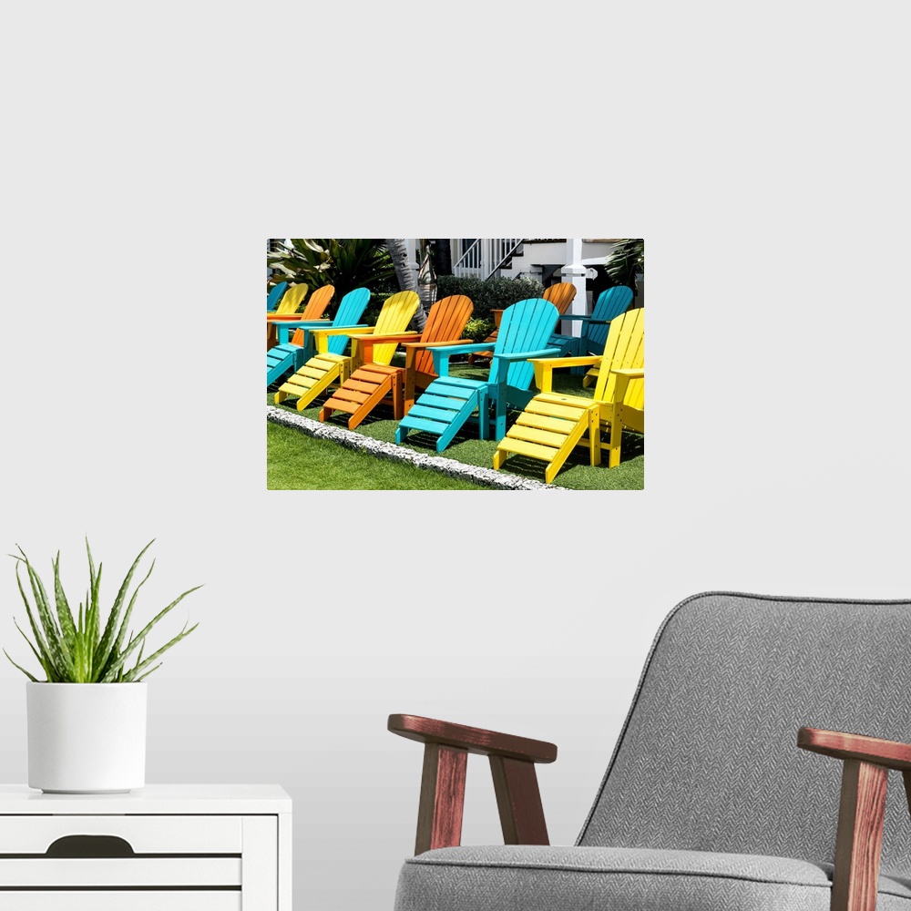 A modern room featuring A collection of brightly painted Adirondack chairs.