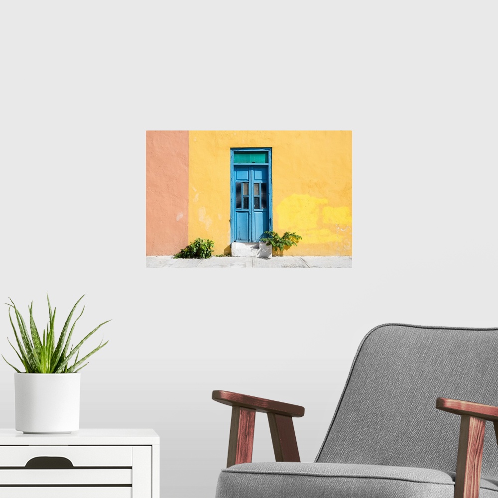 A modern room featuring Photograph of a pale yellow and pink exterior wall with a bright blue door off the street in Mexi...