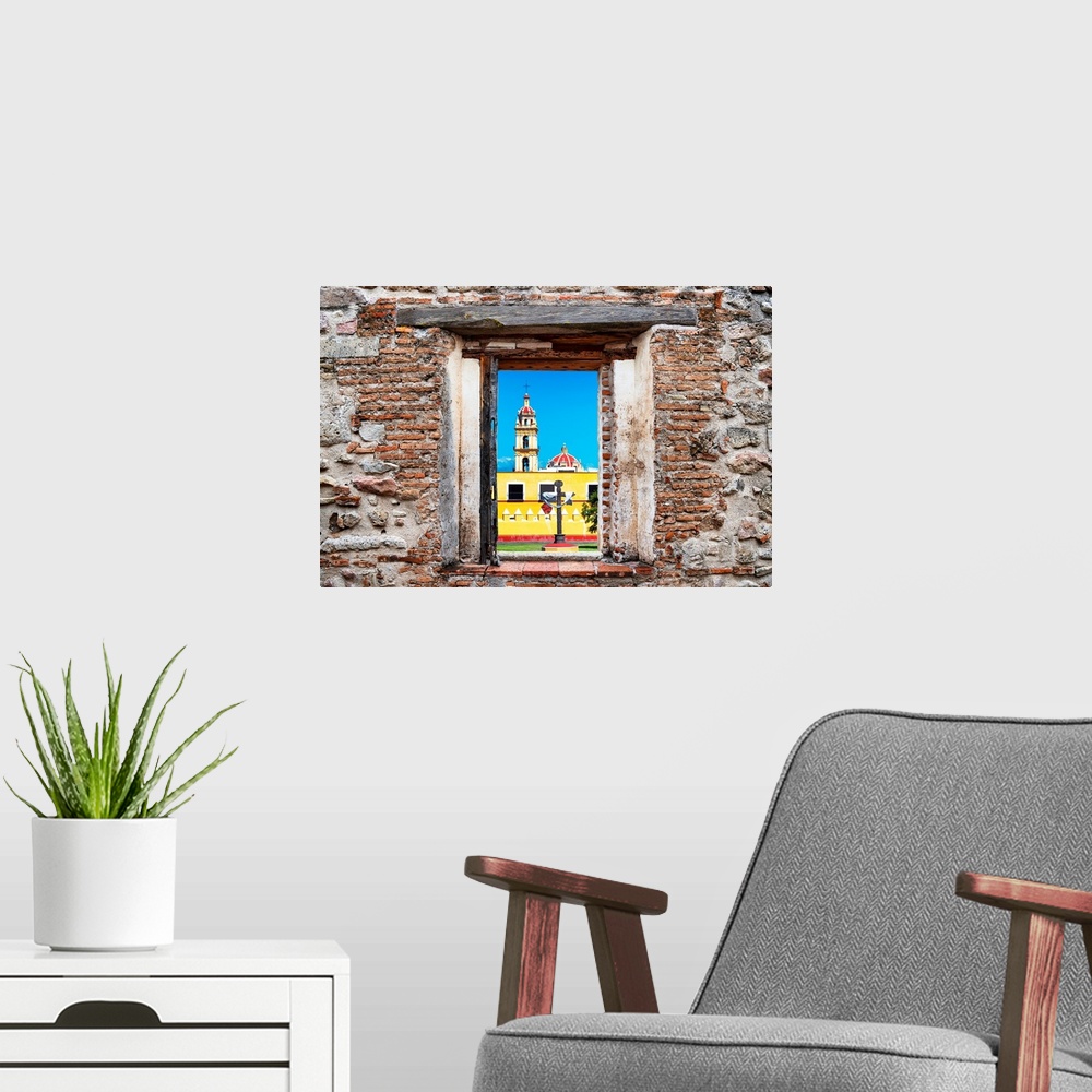 A modern room featuring View of a Courtyard of a Church in Puebla, Mexico, framed through a stony, brick window. From the...