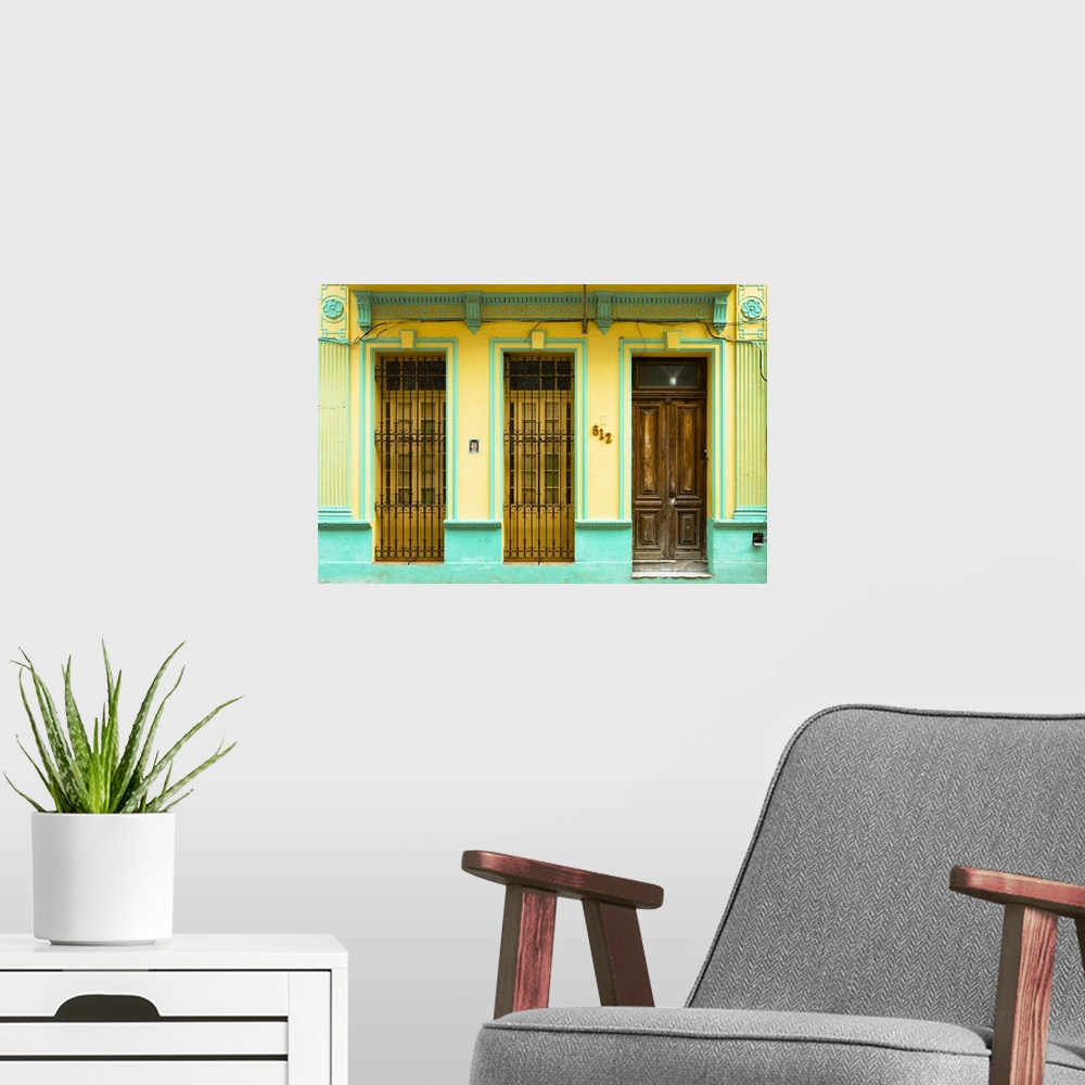 A modern room featuring Photograph of a turquoise and yellow building facade with two windows and a wooden door in Havana...