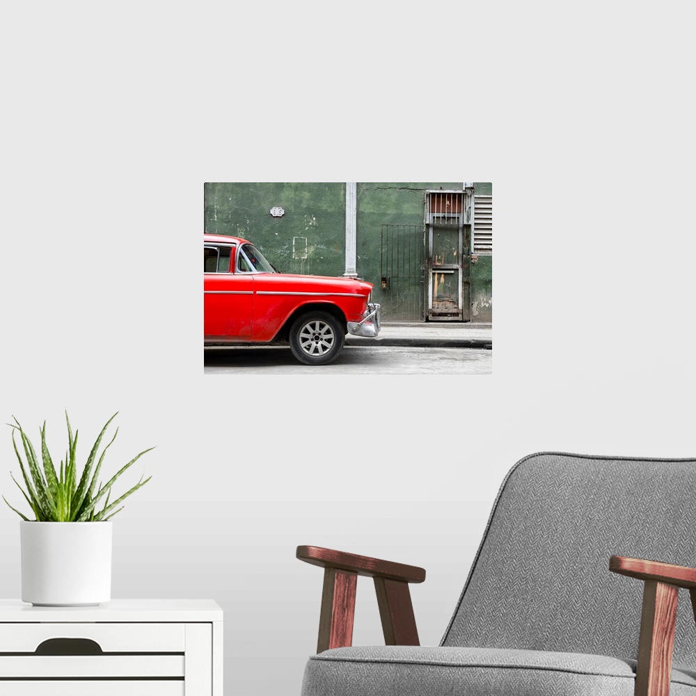 A modern room featuring Photograph of the front of a bright red vintage car with a dark green building in the background ...