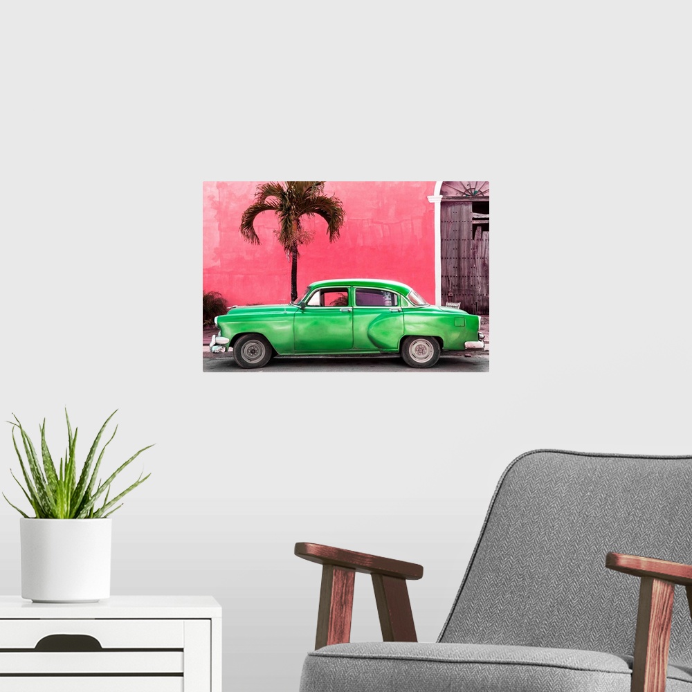 A modern room featuring Photograph of a green vintage car parked outside of a bright pink building with a palm tree.