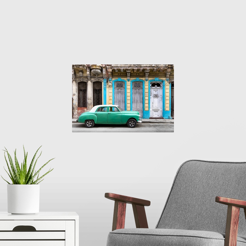 A modern room featuring Photograph of a green vintage car with a white roof parked on the street in front of a blue and y...