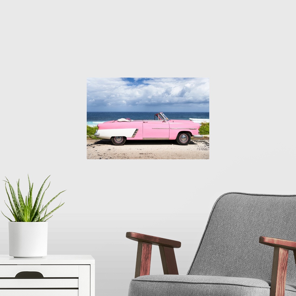 A modern room featuring Photograph of a light pink and white vintage convertible parked in front of the ocean.