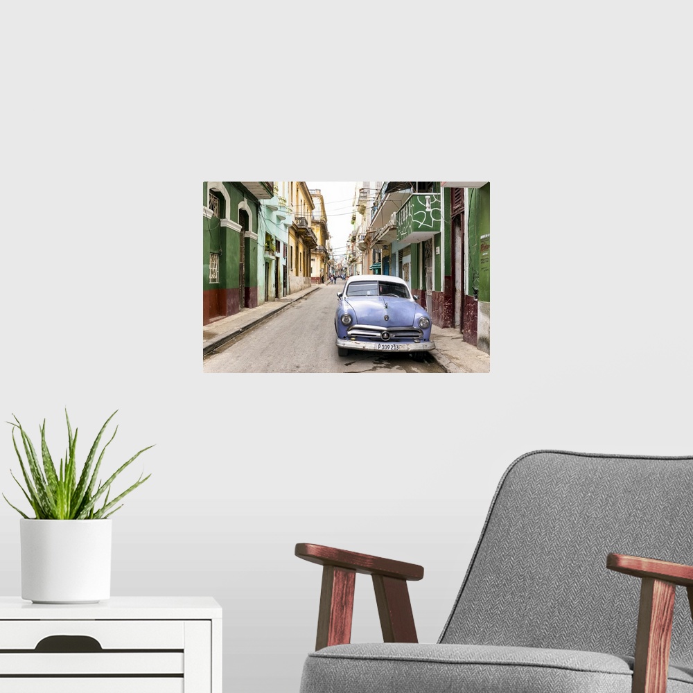 A modern room featuring Photograph of a blue vintage Ford car parked in a Havana street surrounded by buildings.