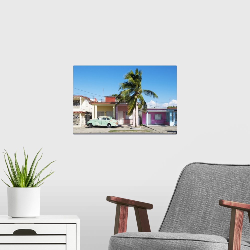 A modern room featuring Photograph of an old car parked in font of a house in Cuba.