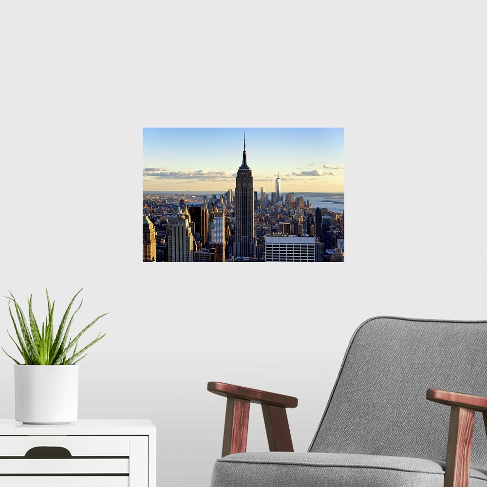 A modern room featuring A sunset creates dramatic lighting on the Empire State Building and New York skyscrapers.