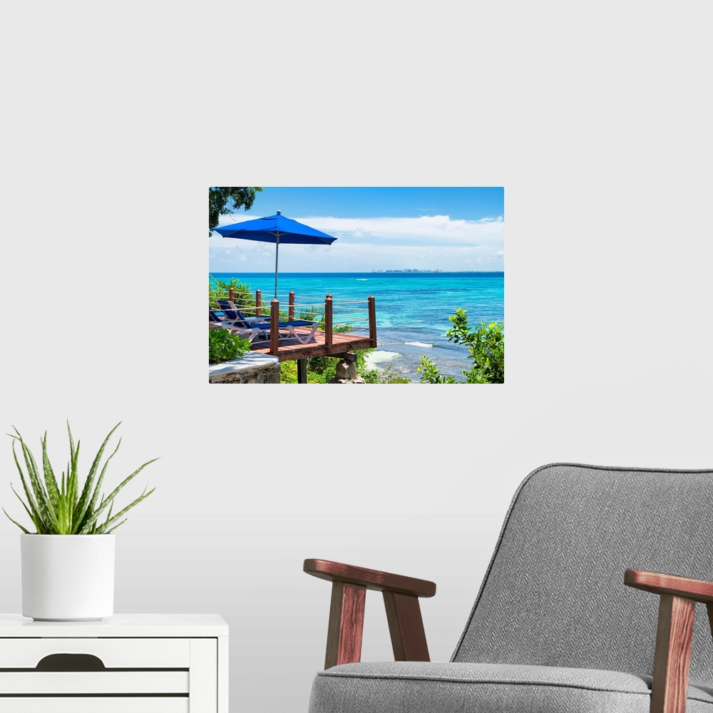 A modern room featuring Relaxing photograph of the clear Caribbean ocean with lounge chairs, an umbrella, and a city skyl...