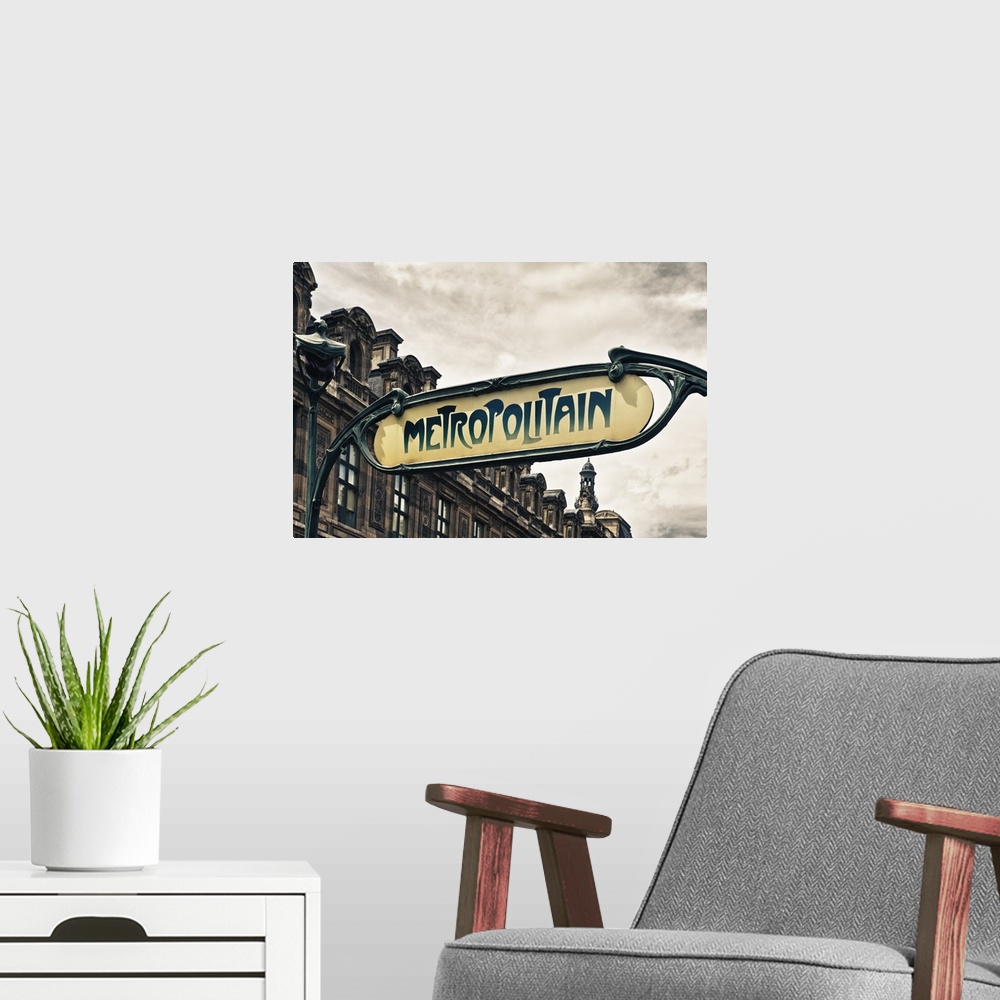 A modern room featuring Sign for an entrance to a Paris Metro station, or subway.