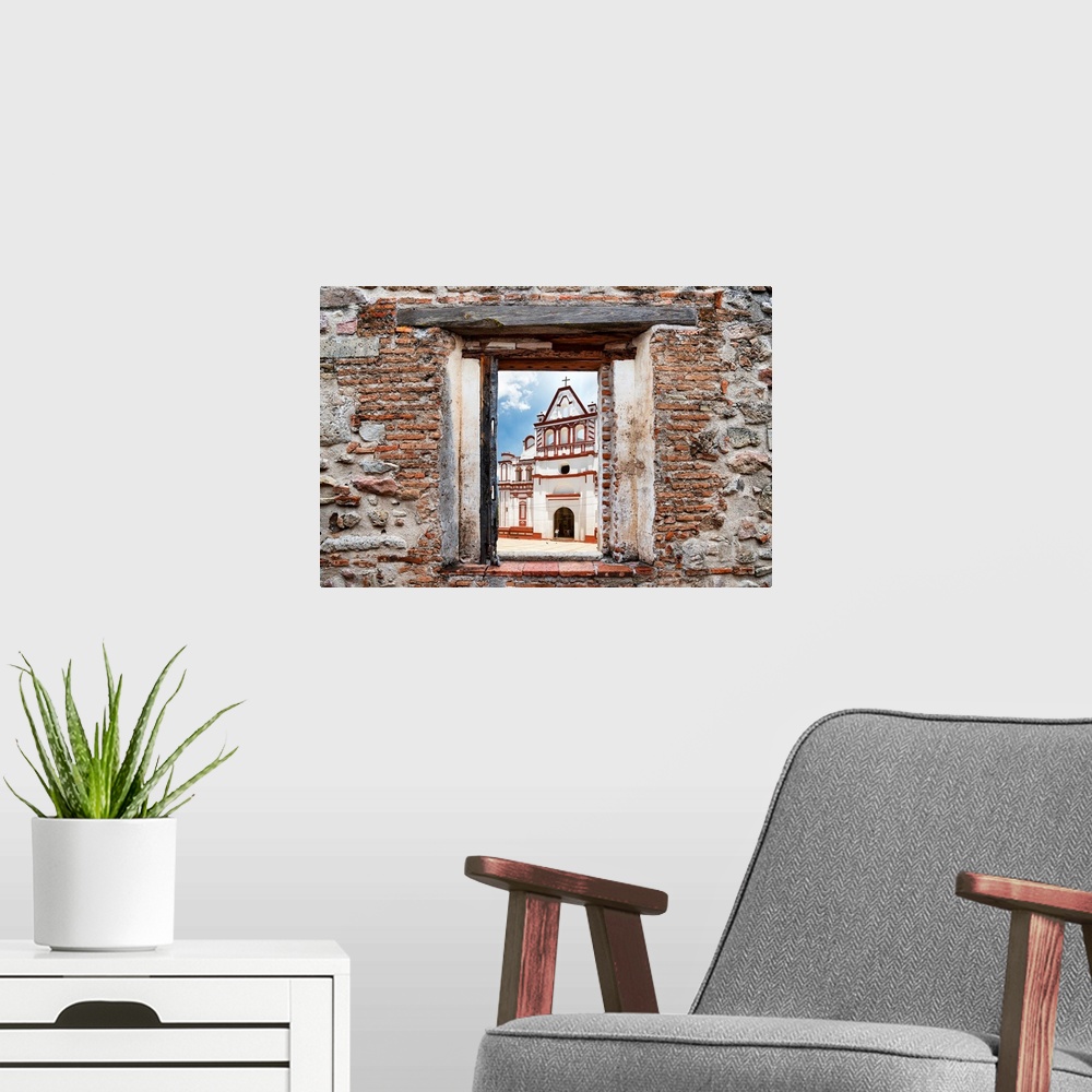 A modern room featuring View of a white and red church in Mexico framed through a stony, brick window. From the Viva Mexi...
