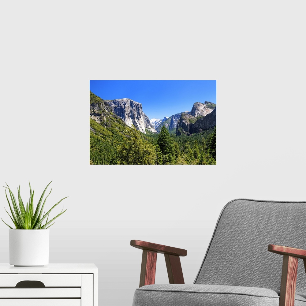 A modern room featuring The majestic peaks of Half Dome and its neighboring mountains over the forests of Yosemite Nation...