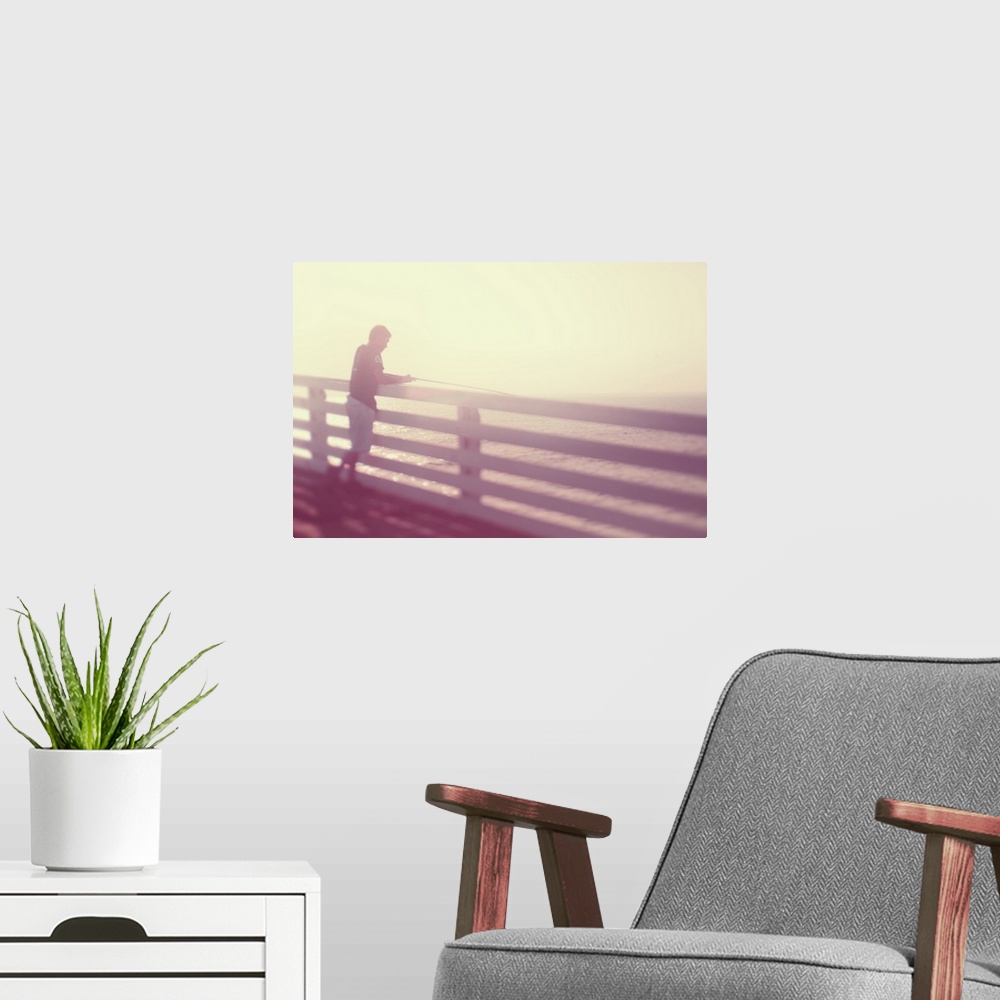 A modern room featuring Pictorialist photo of a person fishing from the pier in the sunshine in pink hues.