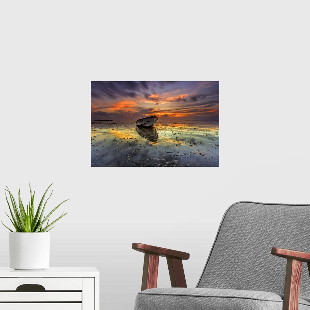 A modern room featuring Dramatic sunset over a seascape with a row boat in the foreground.