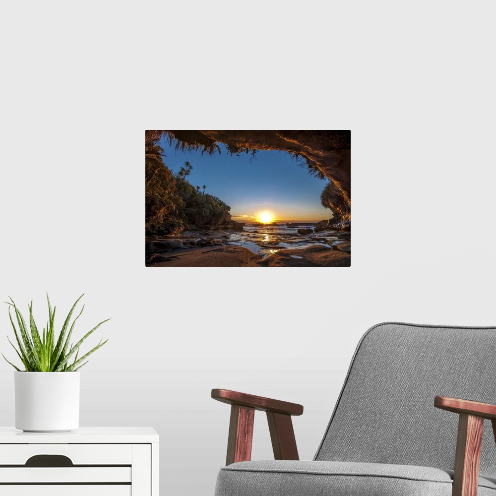 A modern room featuring Sunset on the ocean from a cave on the New Zealand coast.