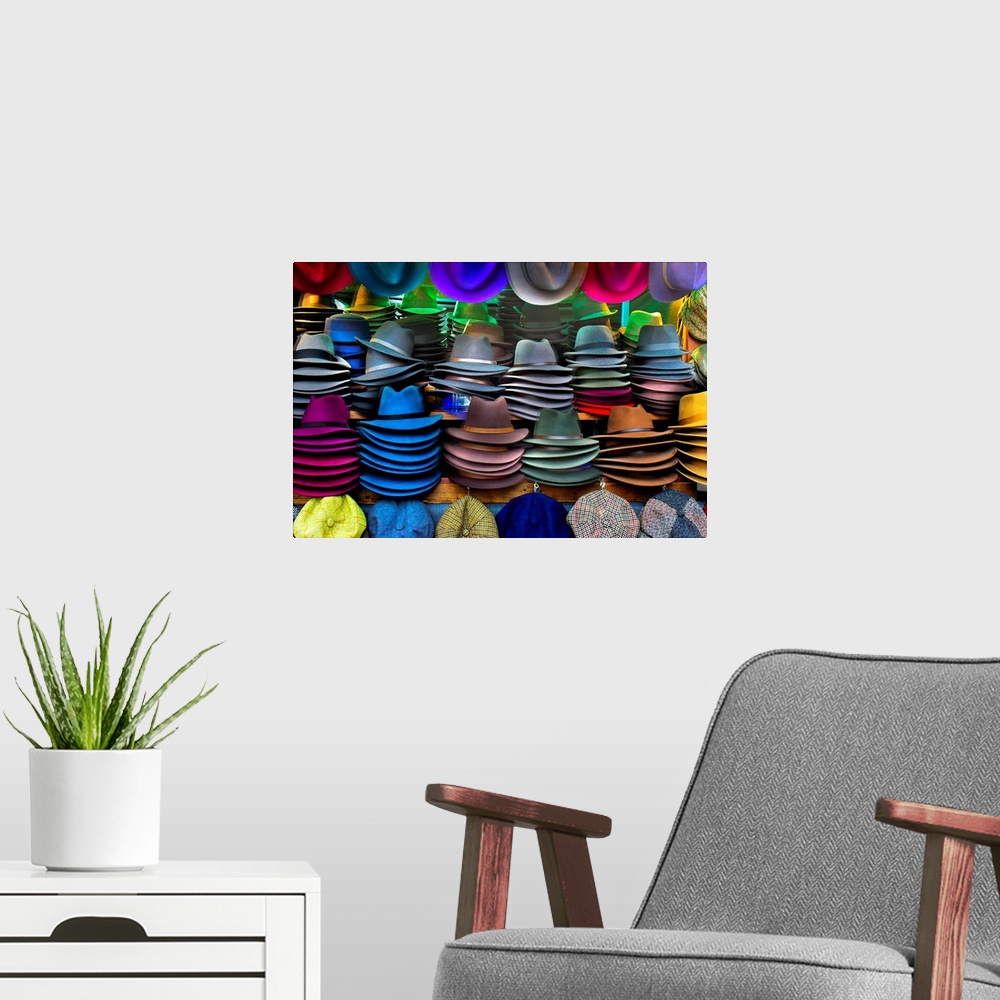 A modern room featuring Several hats of different colors available for sale at a market.