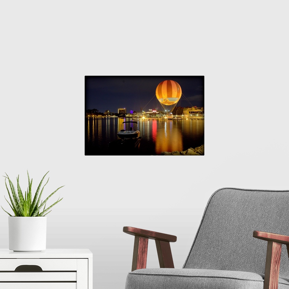 A modern room featuring A hot air balloon glowing against the night sky over a lake.