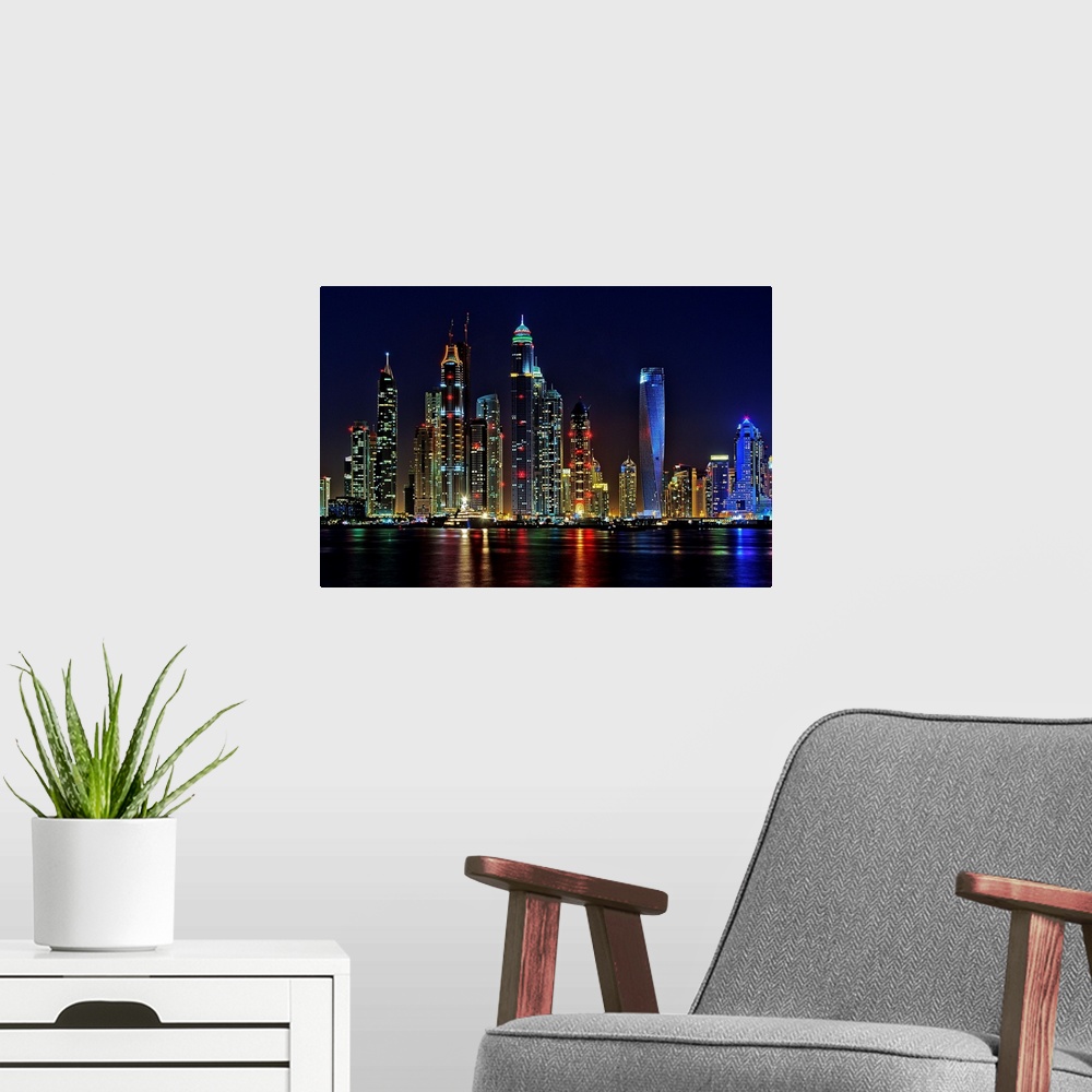 A modern room featuring Dubai skyline at night lit up in neon lights.