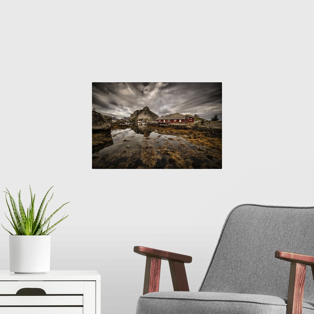 A modern room featuring Dynamic photograph of a fishing village under cloudy skies.