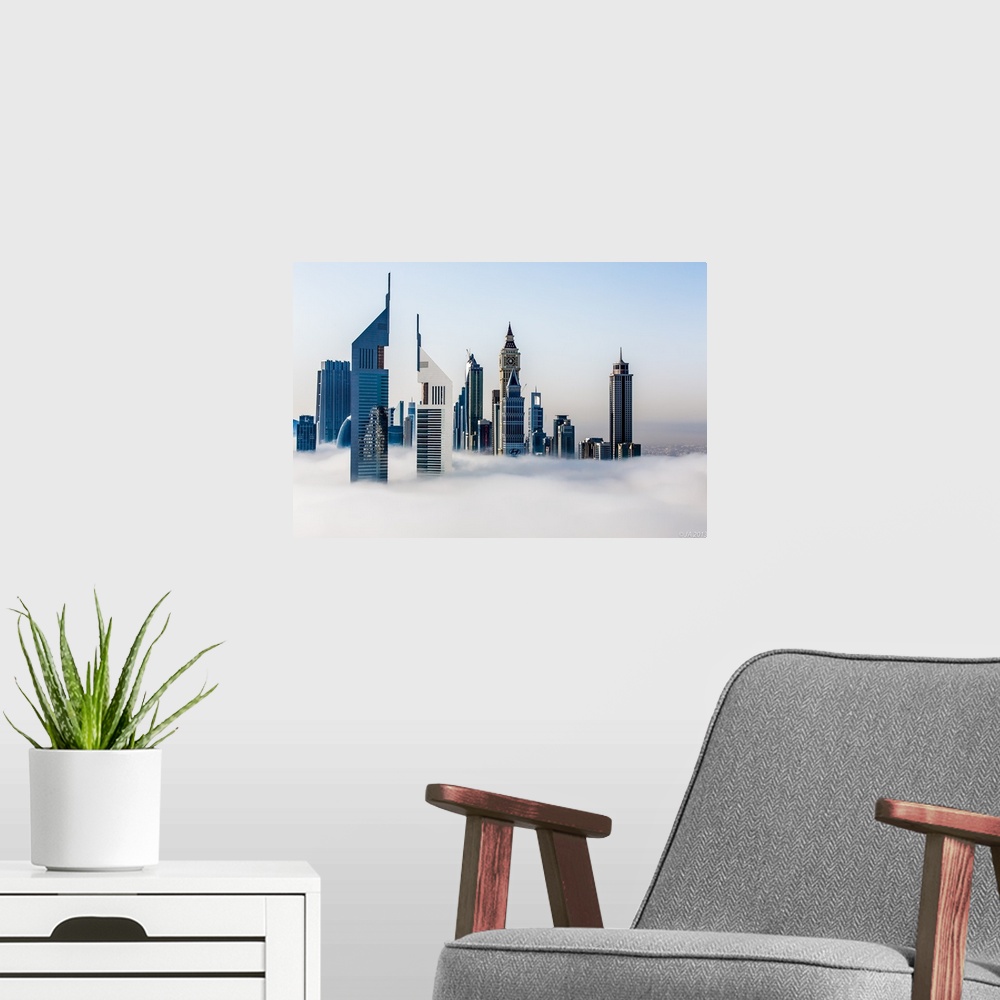 A modern room featuring Jumeirah Emirates Towers stand tall in the fog with the Arabian Gulf in the background.
