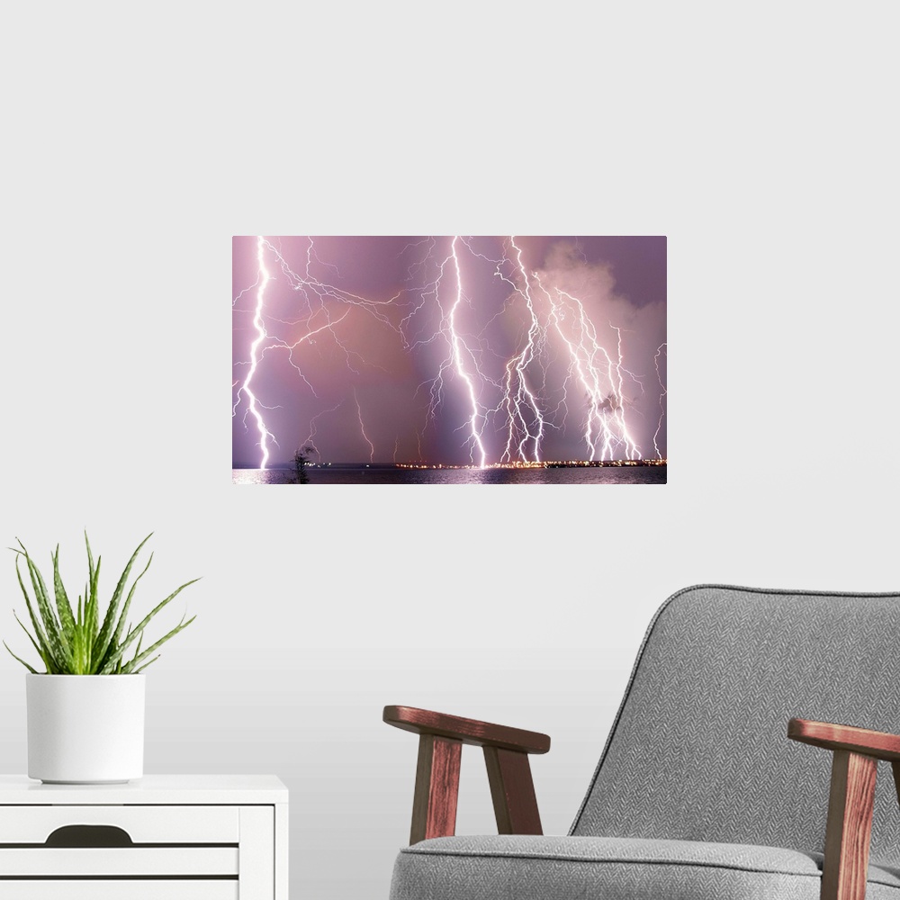 A modern room featuring Multiple lightning strikes during a storm over a city.