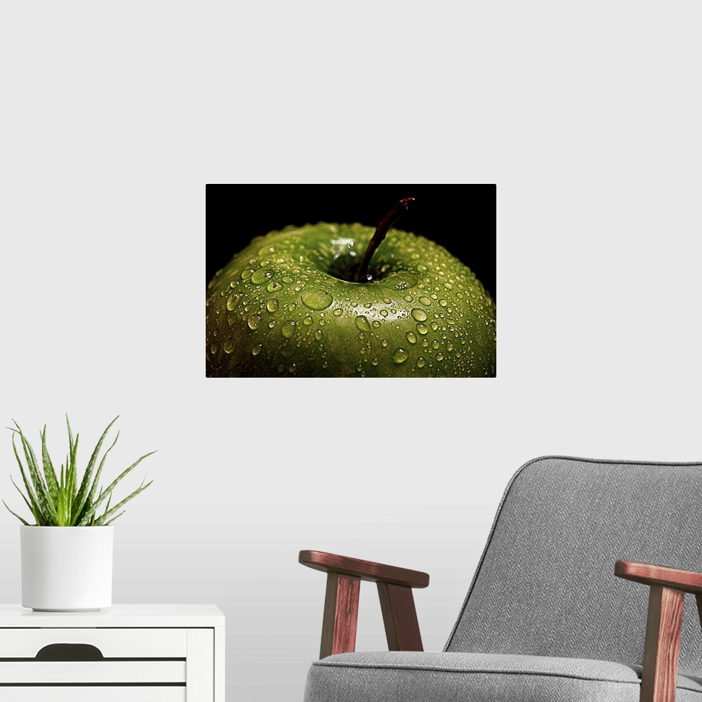 A modern room featuring A bright green apple covered in water droplets.