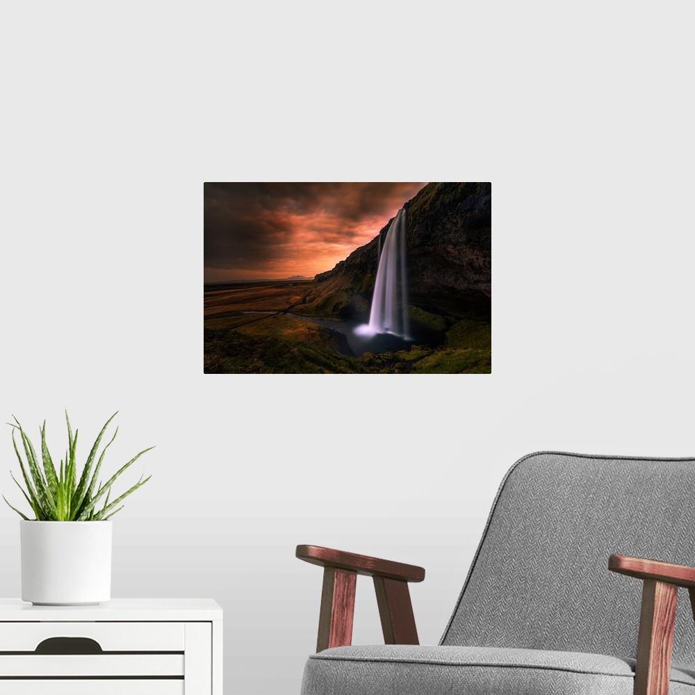 A modern room featuring Seljalandsfoss Waterfall in Southern Iceland in the evening.