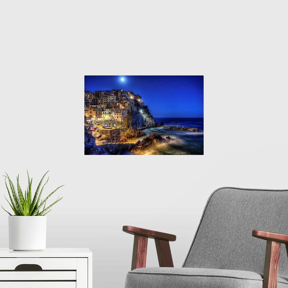 A modern room featuring Buildings at the edge of the sea, Cinque Terre, Italy, at night.