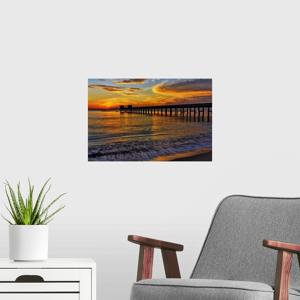 A modern room featuring Sunrise over the water from a beach.